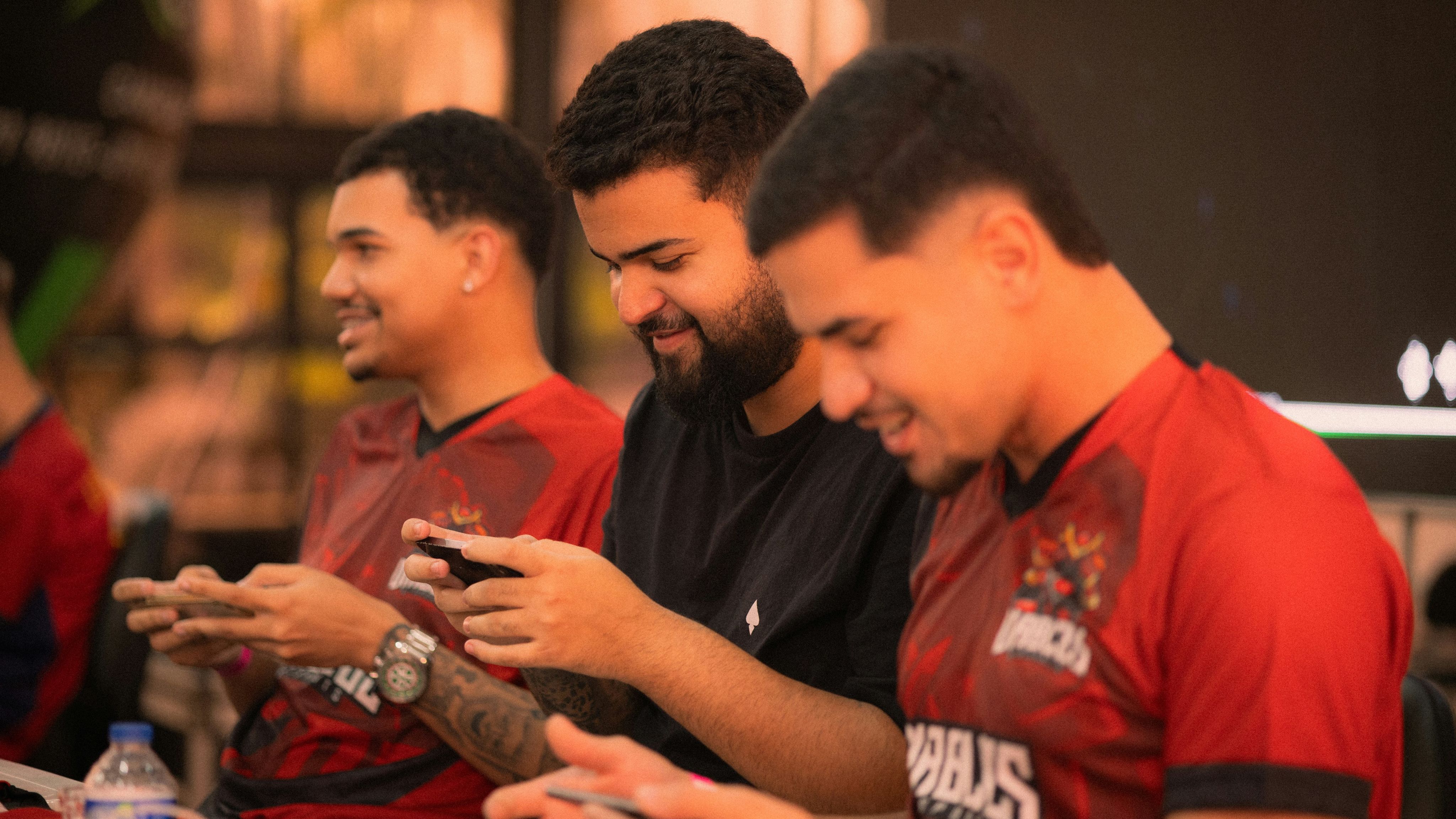 Three men playing mobile games together